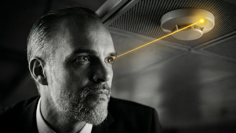 Ki- erstellt: Christian Harrer bei der fachlichen Analyse eines Brandschutzsensors – hochwertige Schwarz-Weiß-Fotografie. CH Unternehmensberatung.