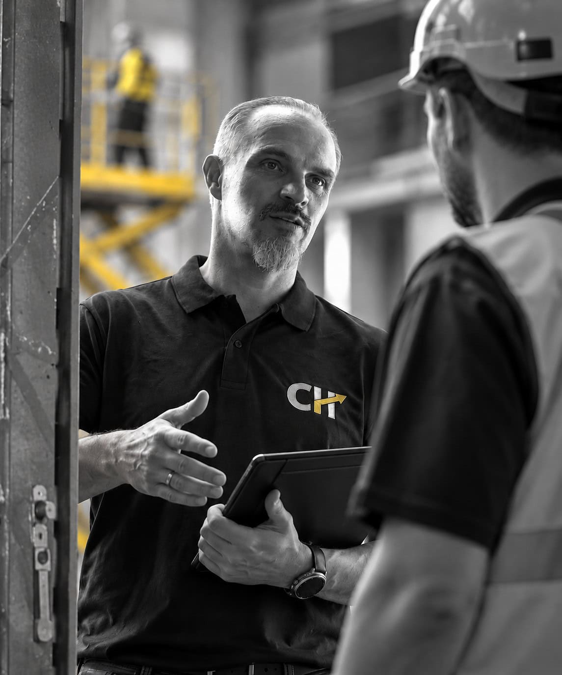 Christian Harrer bei einer HSE-Begehung im Gespräch mit einem Mitarbeiter in einer industriellen Arbeitsumgebung – praxisnahe Beratung zu Arbeitsschutz und Arbeitssicherheit.