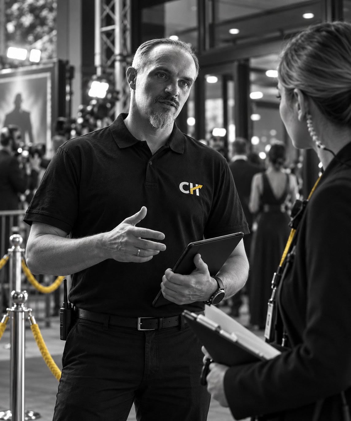 Christian Harrer koordiniert eine Red-Carpet-Kinopremiere im Gespräch mit einer Mitarbeiterin – Event- und Production-Safety in einer dynamischen Veranstaltungsumgebung.