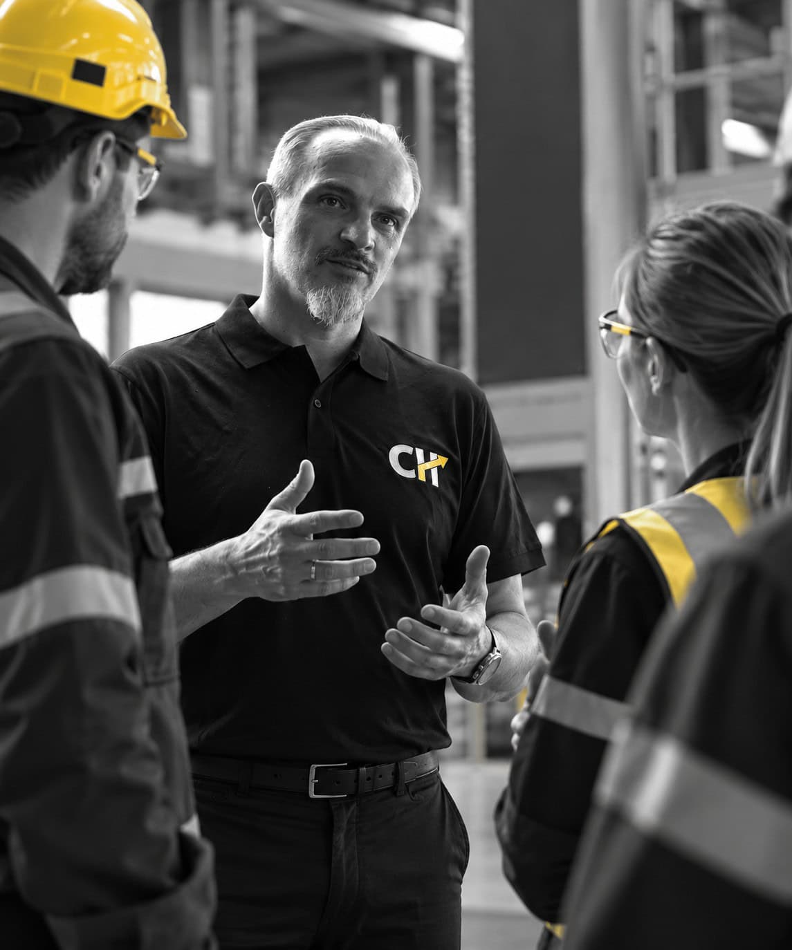 Christian Harrer im Austausch mit Mitarbeitenden in einer industriellen Arbeitsumgebung – Safety Culture und Führung durch Kommunikation, Vorbildverhalten und gemeinsames Handeln.